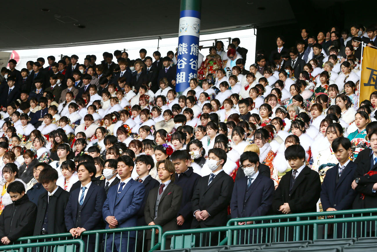 甲子園球場で行われた「令和6年西宮市二十歳のつどい」で能登半島地震の被災者に対して黙とうする参加者（撮影・上山淳一）
