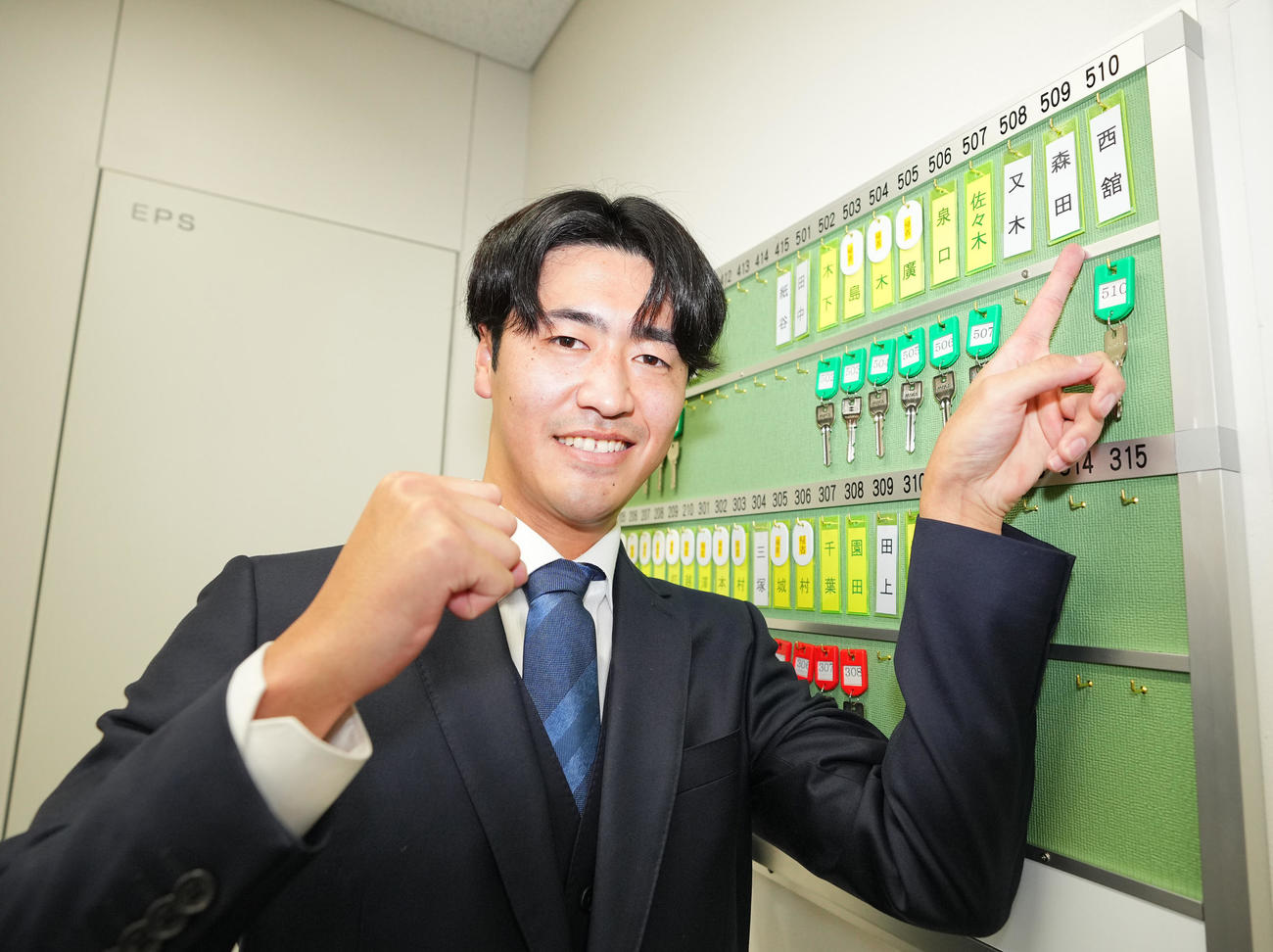 入寮した巨人1位西舘は自分の名札を指さし笑顔を見せる（撮影・垰建太）