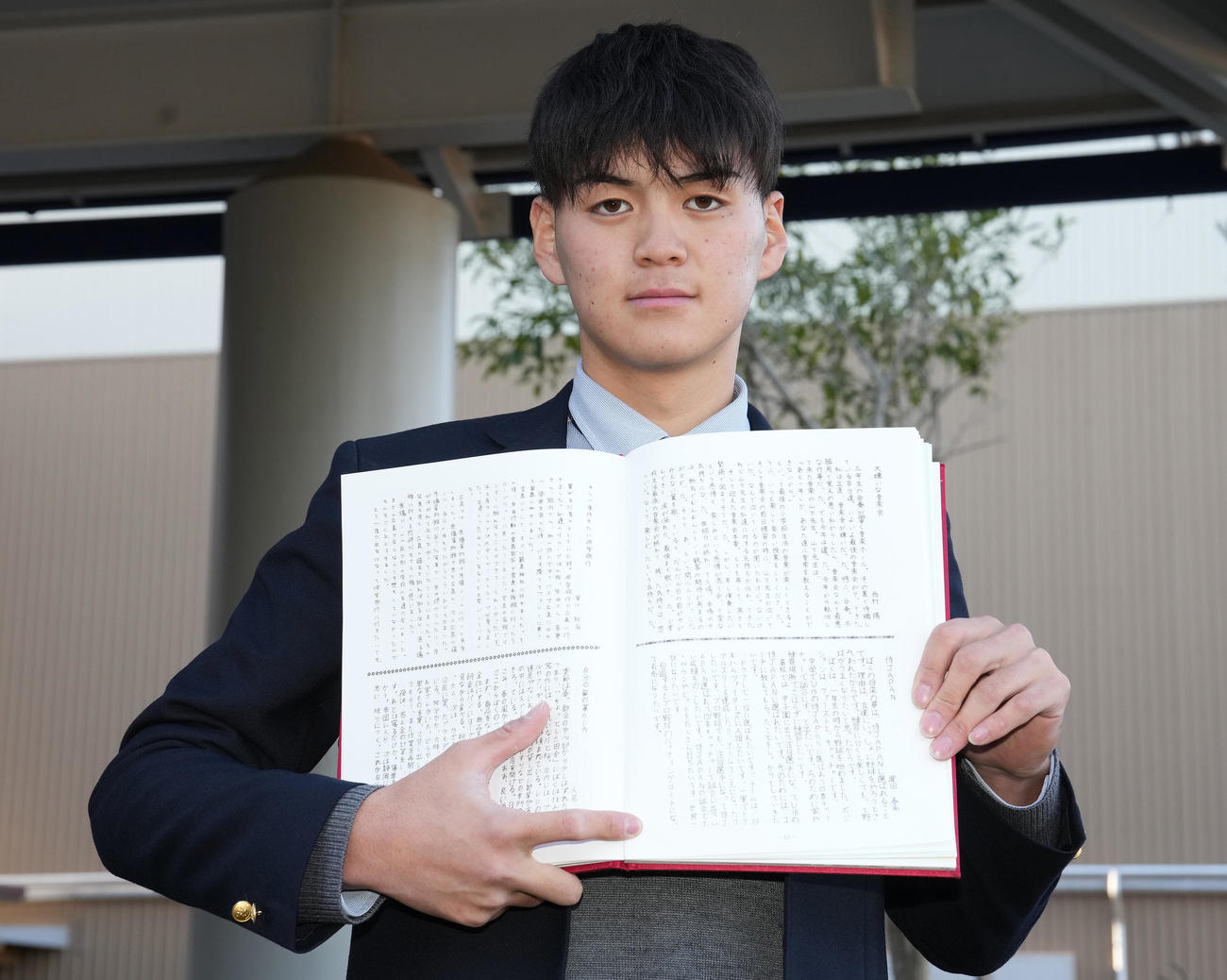 入寮した日本ハム育成1位の浜田は小学校の卒業文集を手に記念撮影（撮影・鈴木みどり）
