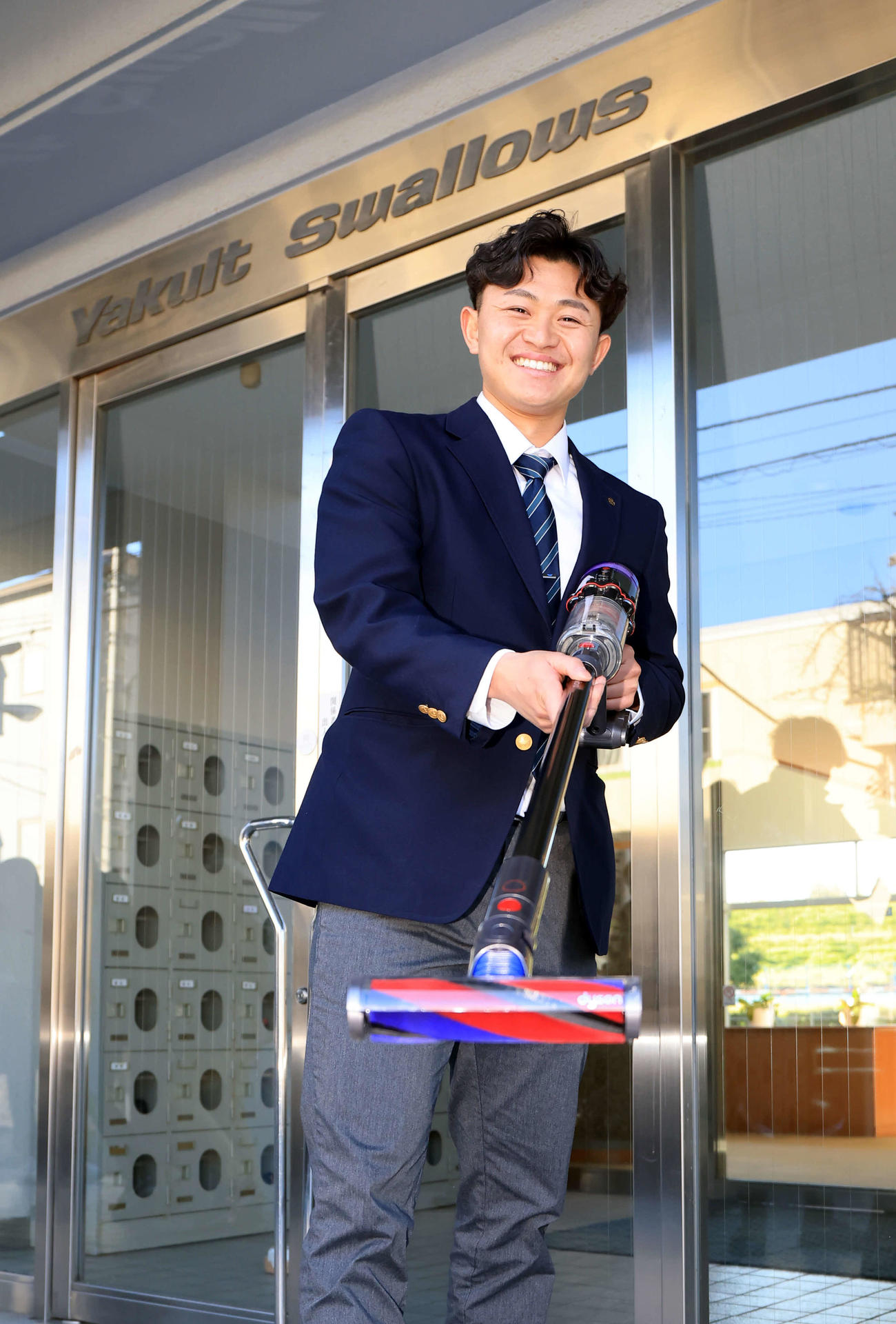 ヤクルト選手寮に入寮したドラフト3位の石原は、持参したダイソンの掃除機をかけて笑顔（撮影・浅見桂子）
