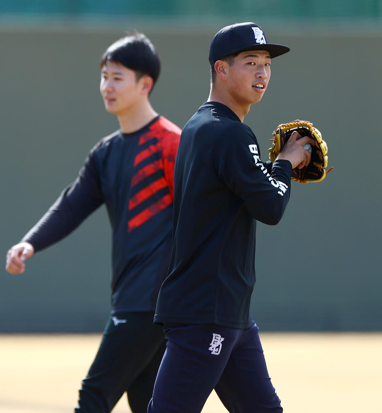 鳴尾浜球場で自主トレする阪神百崎。奥は阪神山田（撮影・上山淳一）