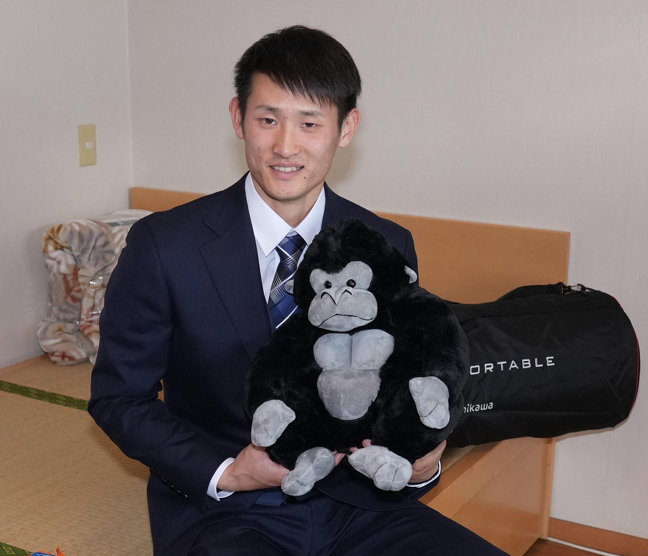 ゴリラのぬいぐるみを手に入寮した中日ドラフト1位草加（撮影・森本幸一）