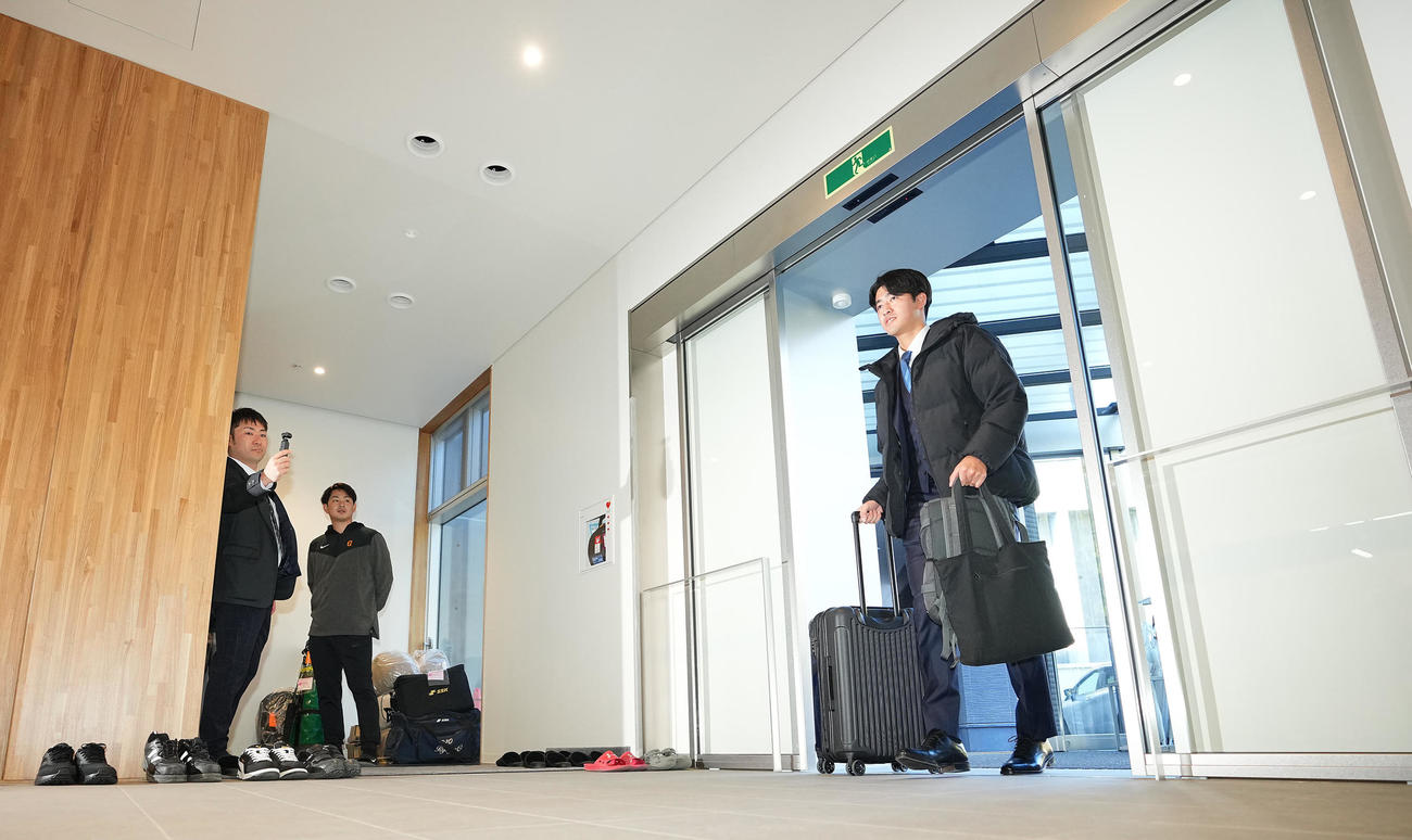 笑顔を見せながら寮に入る巨人1位西舘（撮影・垰建太）