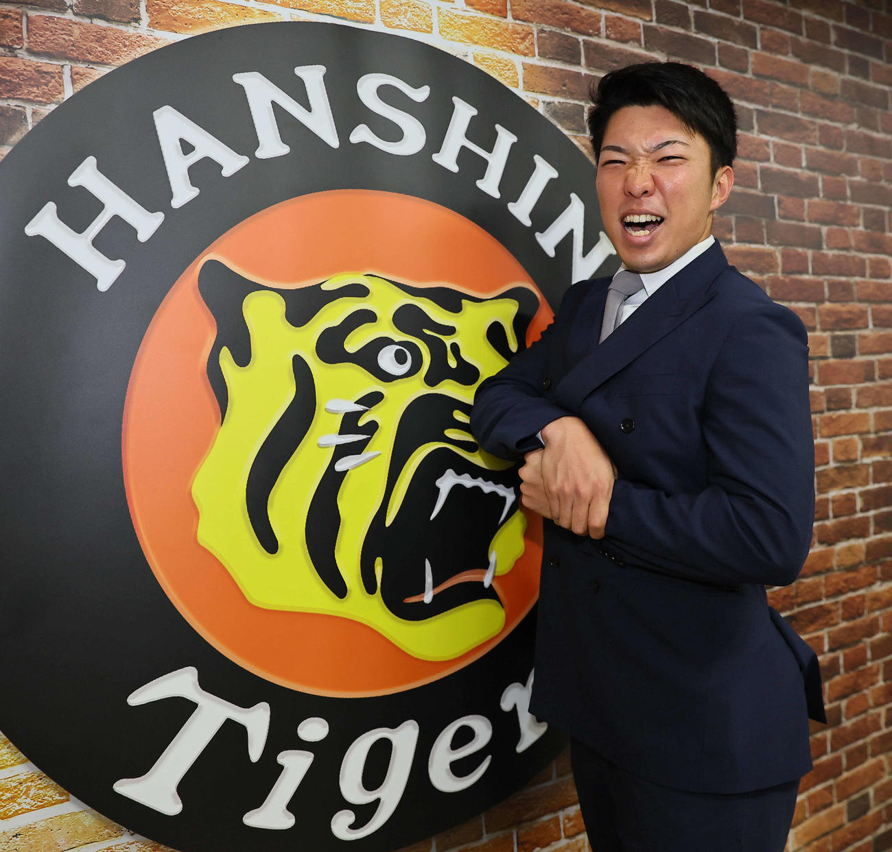 気合の表情でマッスルポーズする石井（2023年12月5日撮影）