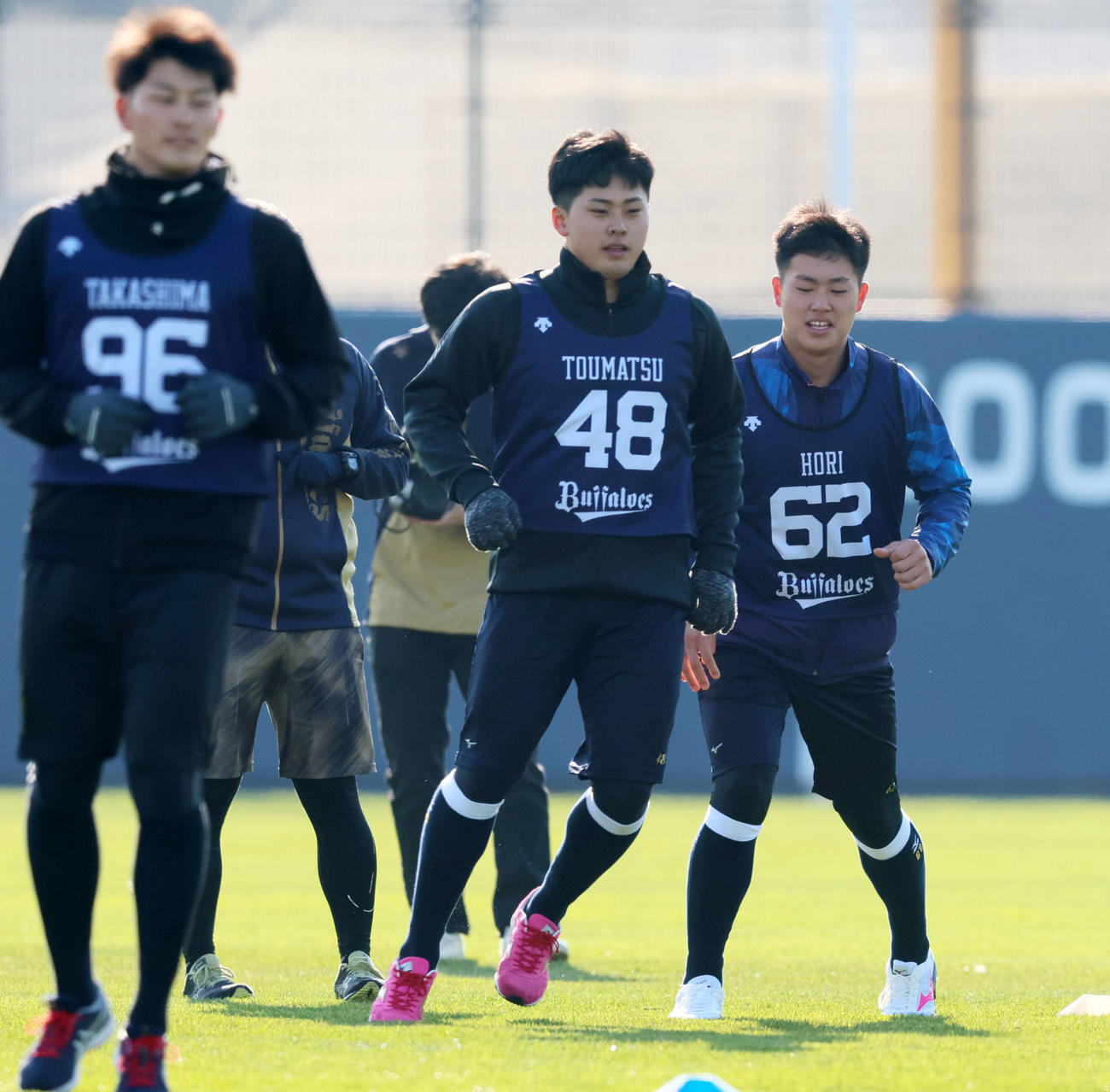 オリックス新人合同自主トレがスタートしウオーミングアップを行う東松ら。右は堀（撮影・加藤哉）