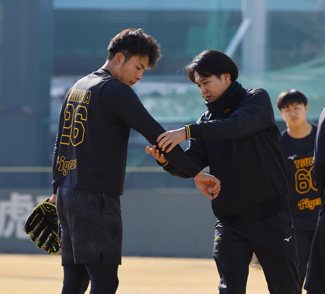 新人合同自主トレでキャッチボールを終え、腕に付けていたベルトを外す椎葉（左）（撮影・藤尾明華）