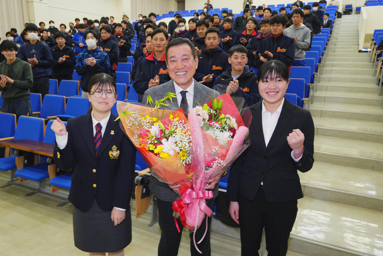 国際武道大学で講義をした原オーナー付特別顧問（中央）は、生徒から花束を受け取り笑顔を見せる（撮影・菅敏）