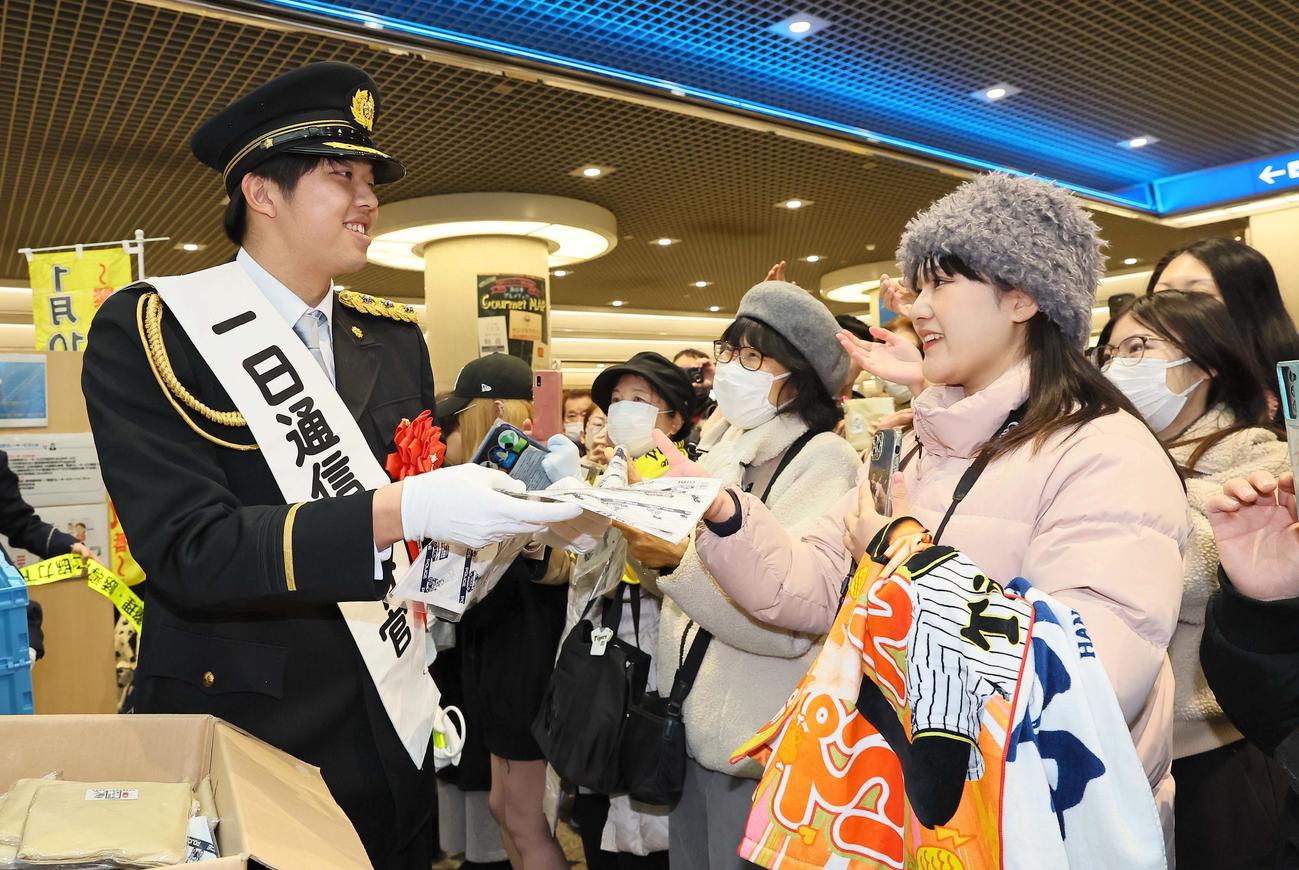 兵庫県警一日通信指令官を務めた阪神才木はイベントで市民に記念品を手渡す（撮影・上田博志）