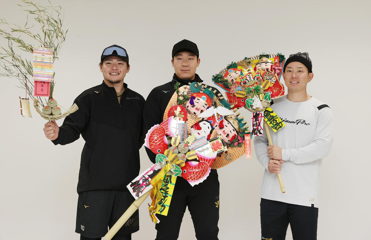 自主トレを公開し、熊手を手に写真に納まる阪神大山（中央）。右は糸原、左は小野寺（撮影・前田充）