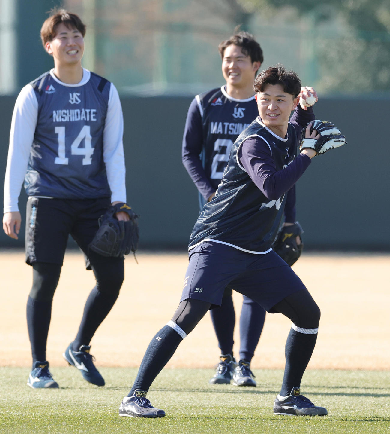 新人合同自主トレ初日にノックを受けるヤクルト石原。後方左から西舘、松本健（撮影・野上伸悟）
