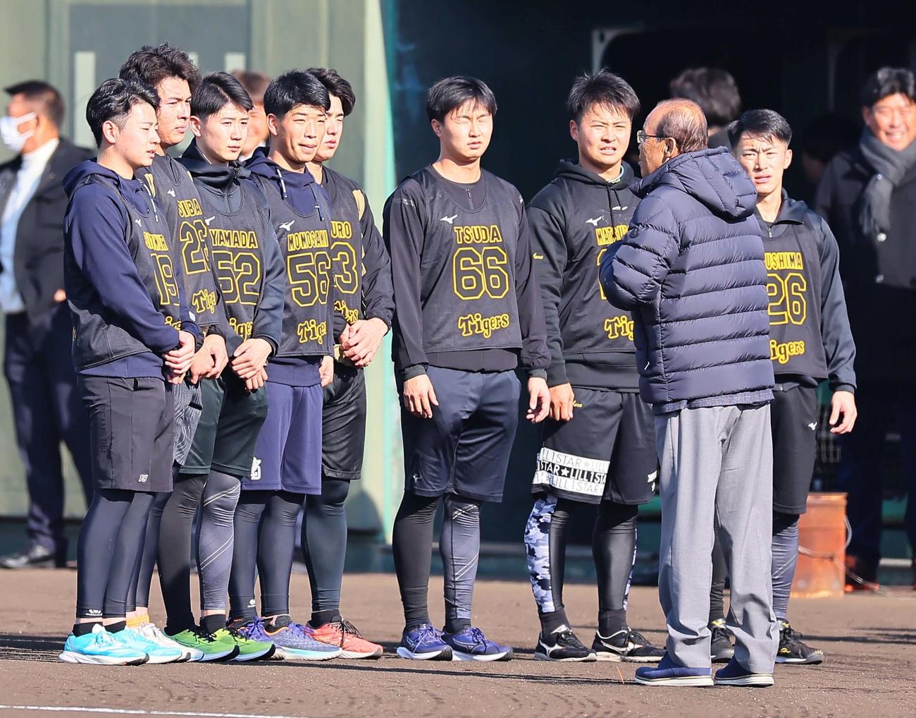 岡田監督（右から2人目）の訓示を聞く左からドラフト1位・下村、2位・椎葉、3位・山田、4位・百崎、5位・石黒、6位・津田、育成ドラフト1位・松原、一人置いて育成ドラフト2位・福島＝2024年1月9日、鳴尾浜球場