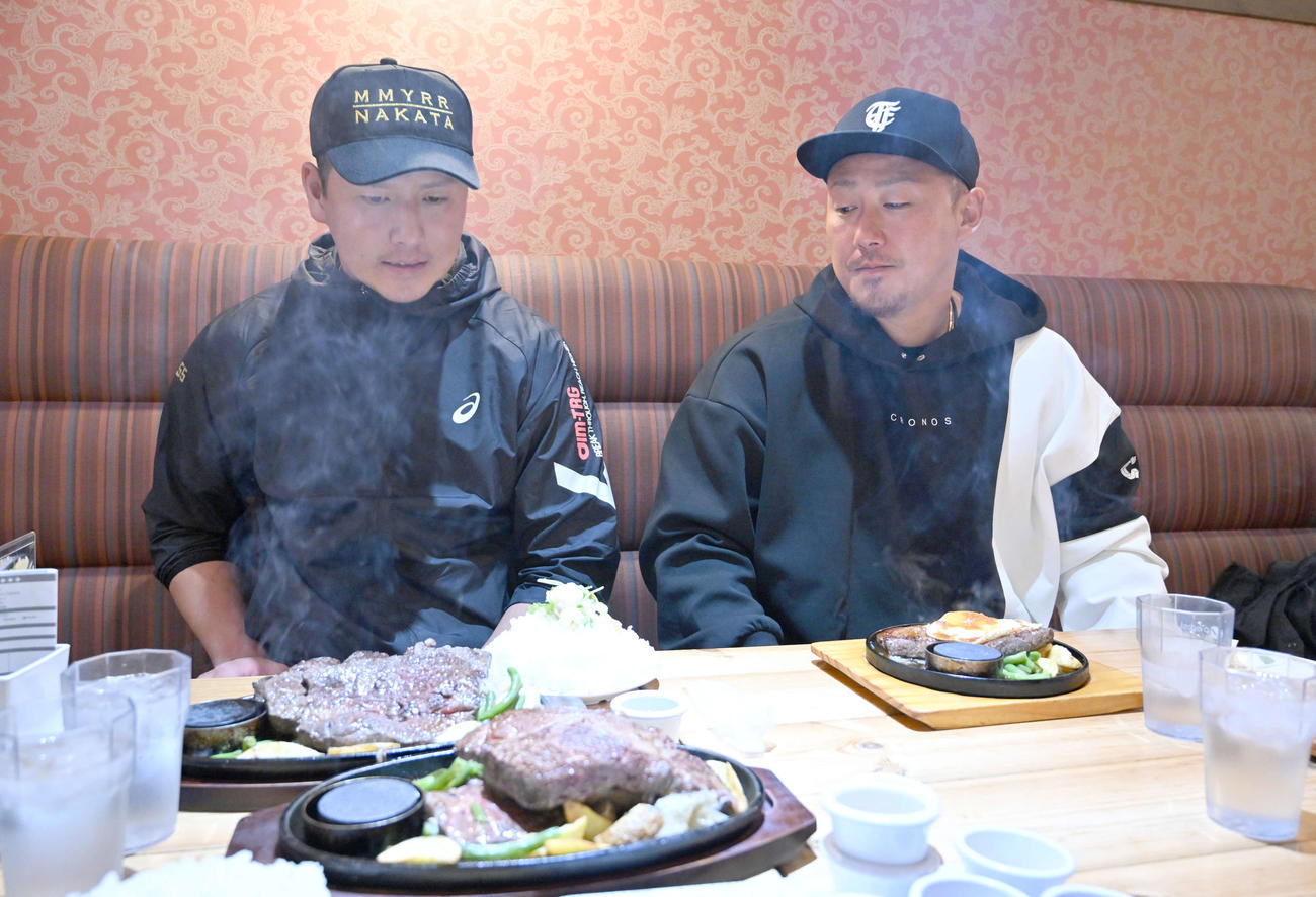 山盛りの白米とステーキを見つめる巨人秋広（左）と中日中田