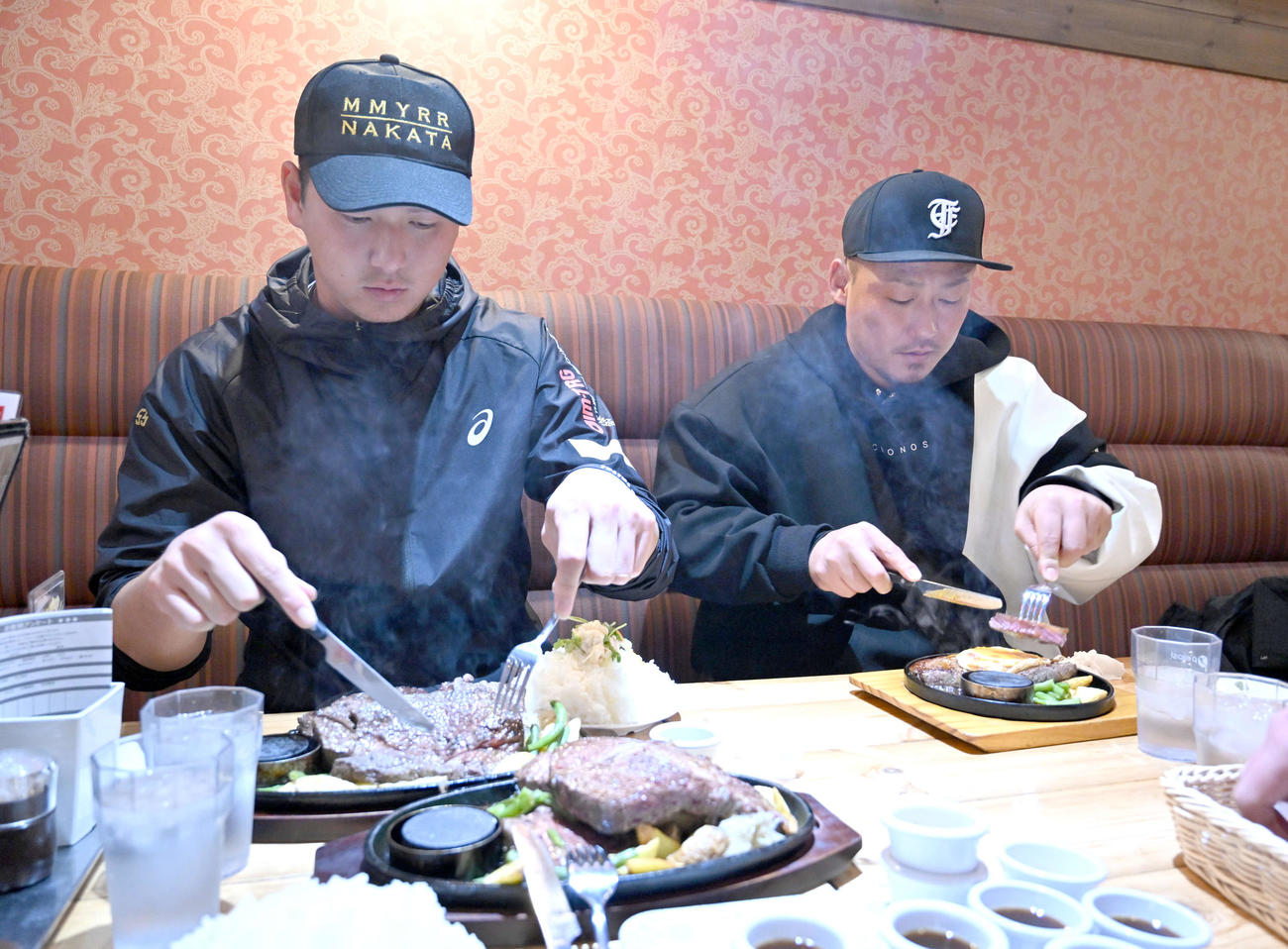黙々とステーキを食べる巨人秋広（左）と中日中田