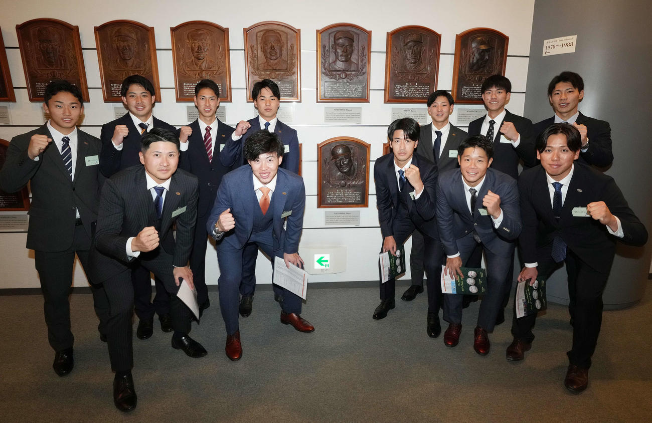 野球殿堂博物館を見学し、長嶋茂雄氏のレリーフを囲み記念撮影に納まる西舘（前列右から3人目）ら巨人の新人選手たち（撮影・鈴木みどり）