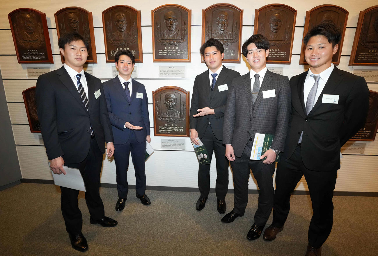 野球殿堂博物館を見学し、沢村栄治氏のレリーフを囲み記念撮影に納まる下村（左から2人目）ら阪神の新人選手たち（撮影・鈴木みどり）