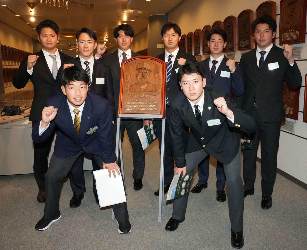 野球殿堂博物館を見学し、バース氏のレリーフを囲み記念撮影に納まる下村（後列右から2人目）ら阪神の新人選手たち（撮影・鈴木みどり）