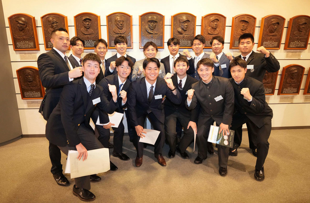 野球殿堂博物館を見学し、王貞治氏のレリーフを囲み記念撮影に納まる前田（後列左から3人目）らソフトバンクの選手たち（撮影・鈴木みどり）