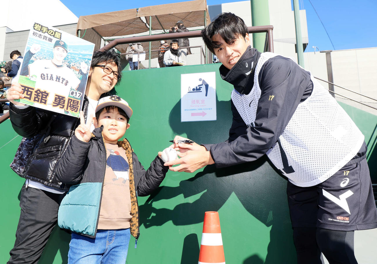 練習後のサイン会で、ファンの子どもと笑顔を見せる巨人西舘勇陽（撮影・浅見桂子）