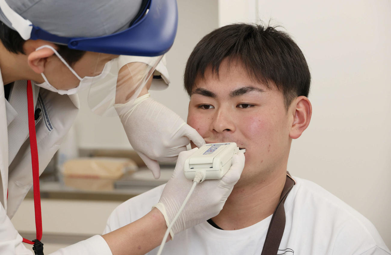 歯科検診で、かむ力を測定する広島ドラフト5位の赤塚（撮影・加藤孝規）