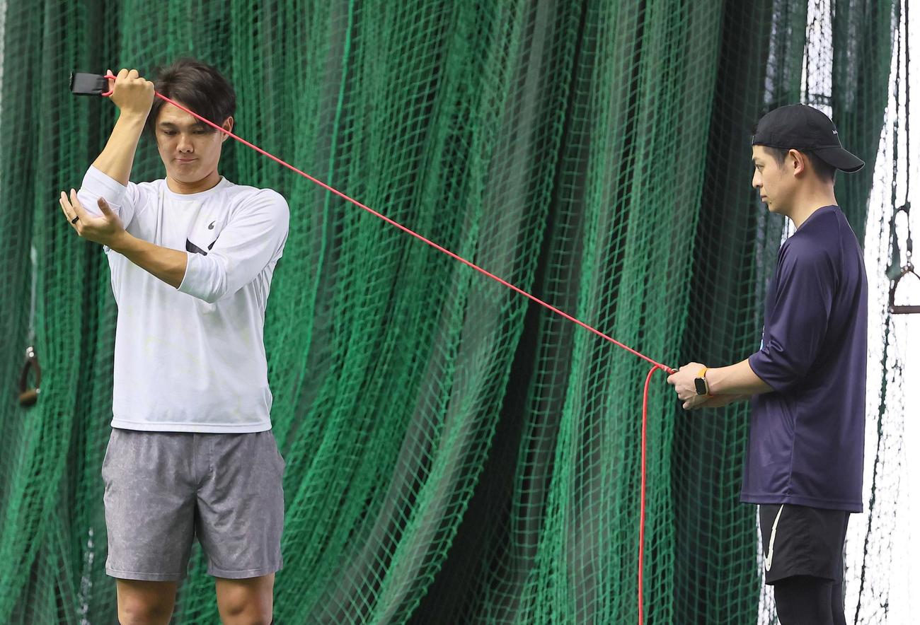 西純（左）はゴムを使ってトレーニングをする（撮影・上田博志）