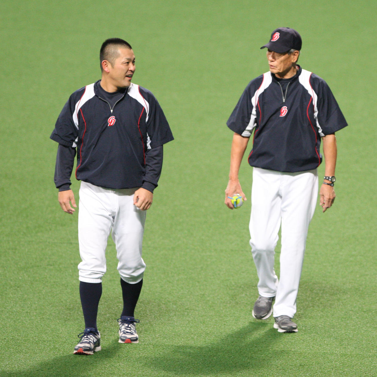 外野で話す谷繁（左）と権藤投手コーチ（2012年4月撮影）