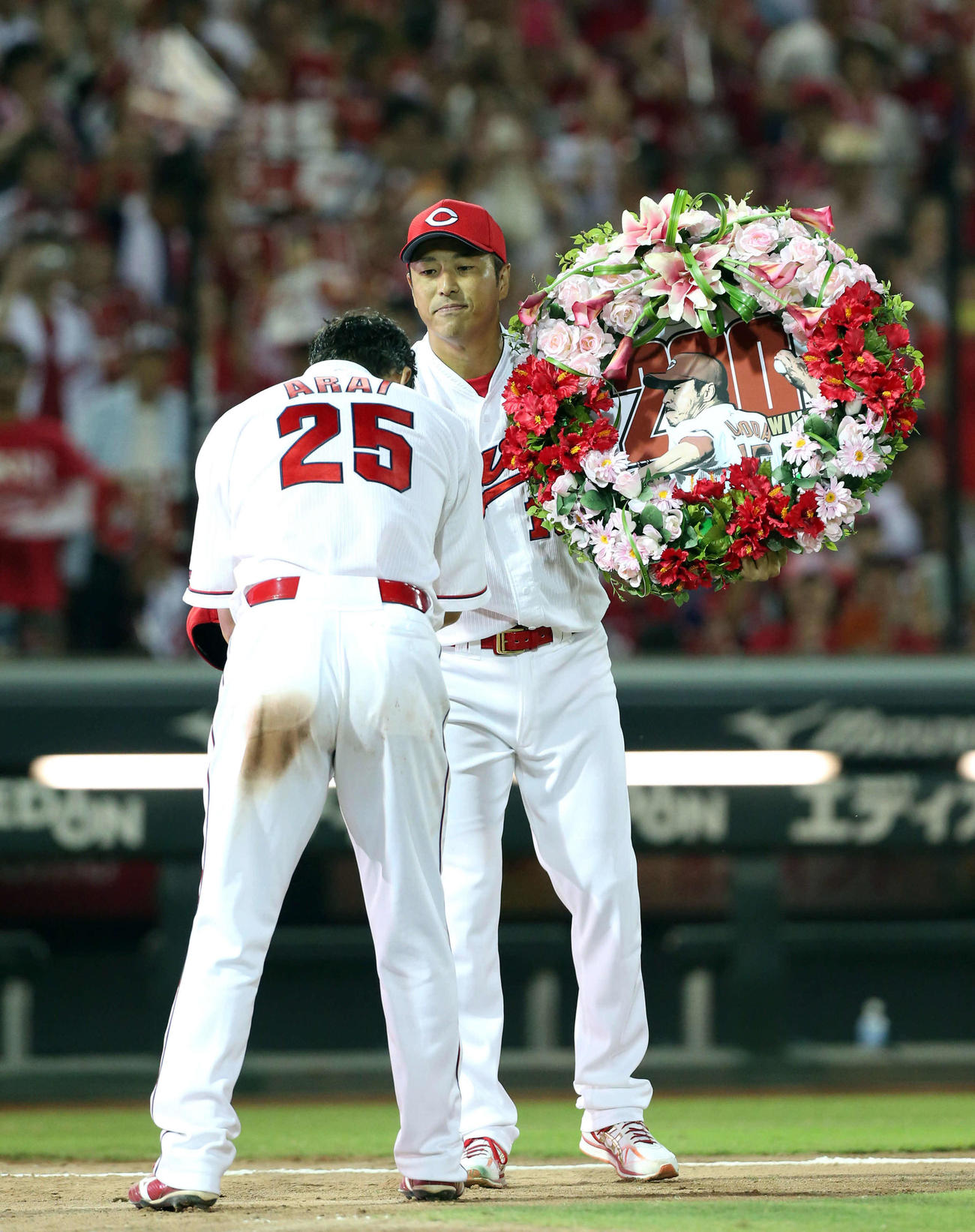 2016年7月23日、日米通算200勝を達成し新井貴浩（左）から記念ボードを受け取る黒田博樹