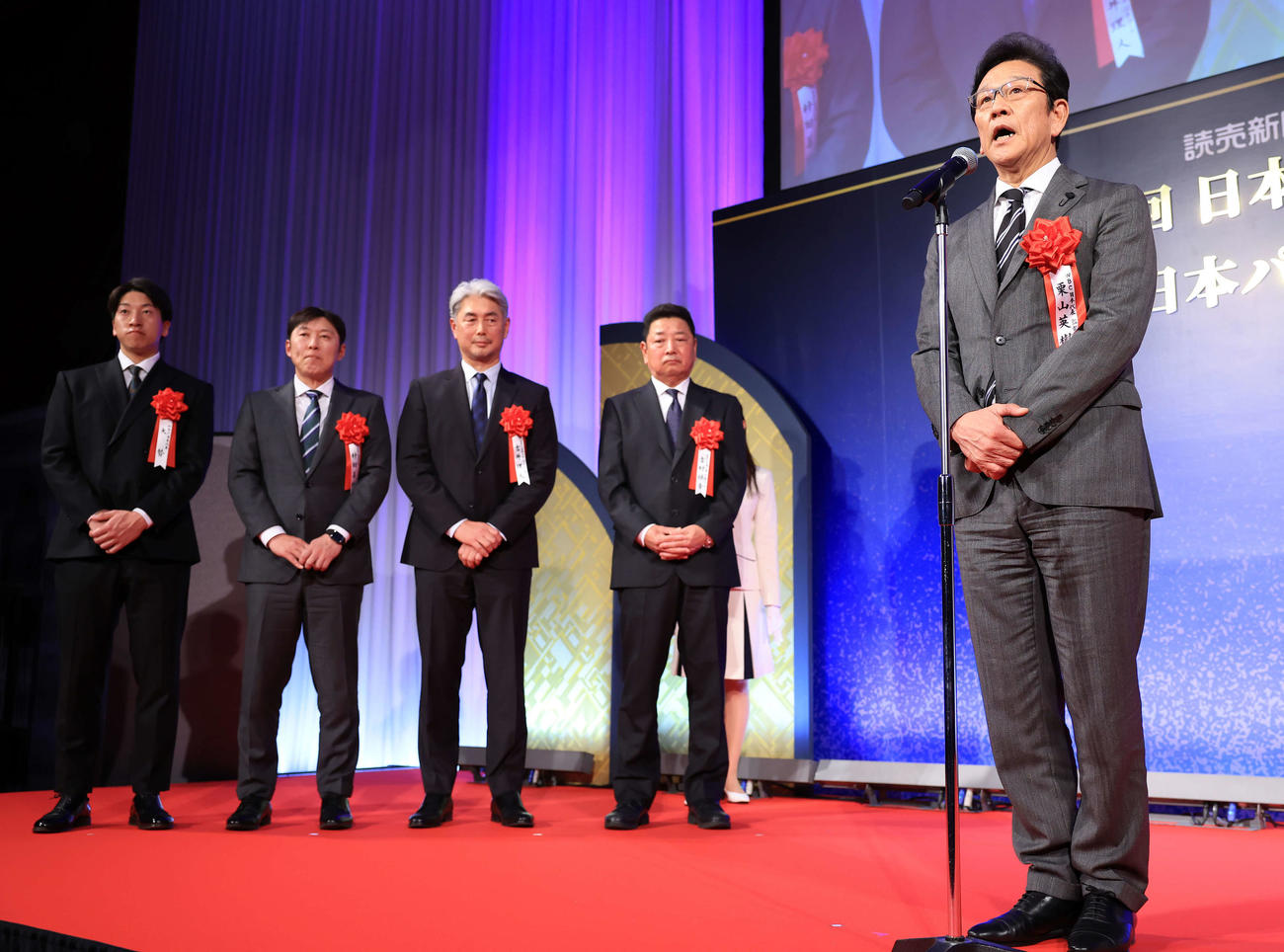 日本スポーツ賞の大賞を受賞し、あいさつする野球日本代表の栗山監督（右）。奥左から大勢、村田コーチ、吉井コーチ、吉村コーチ（撮影・浅見桂子）