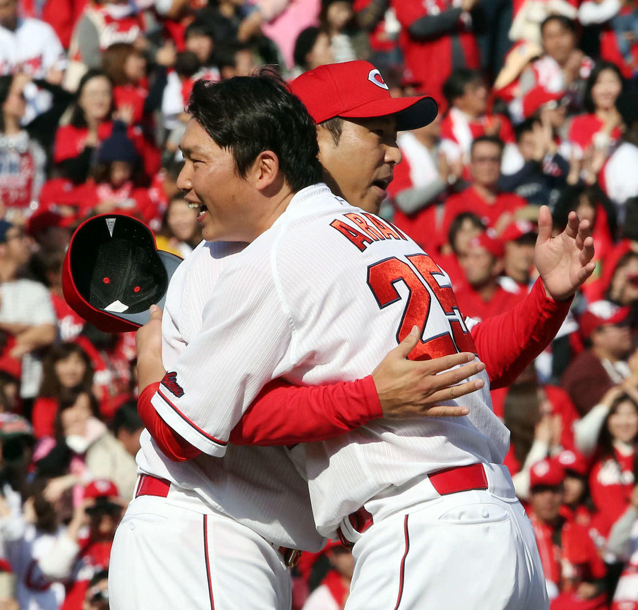 16年11月、優勝報告会で新井貴浩（右）と笑顔で抱擁を交わす黒田博樹