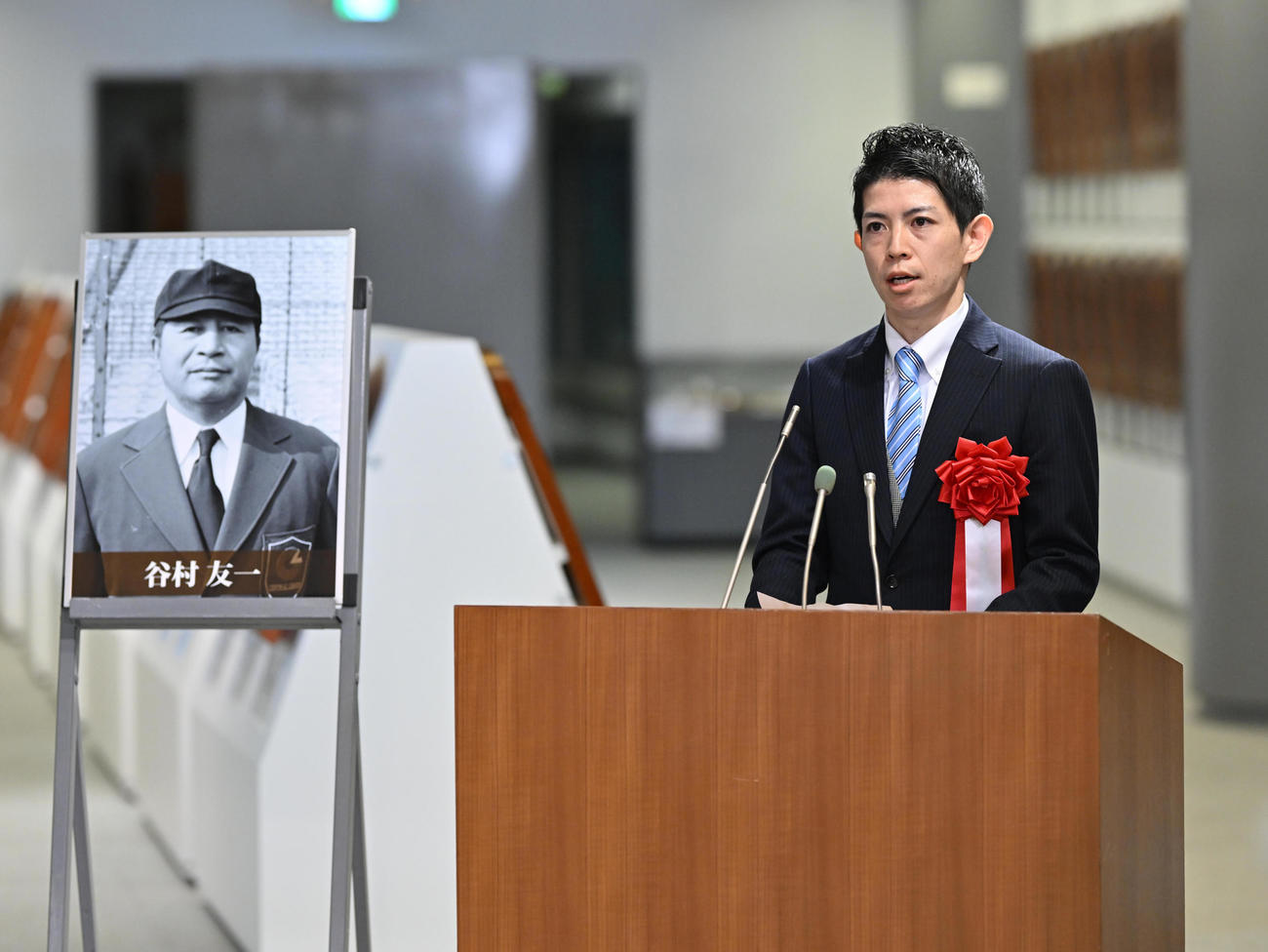 あいさつする故・谷村友一氏の孫の米井氏（代表撮影）