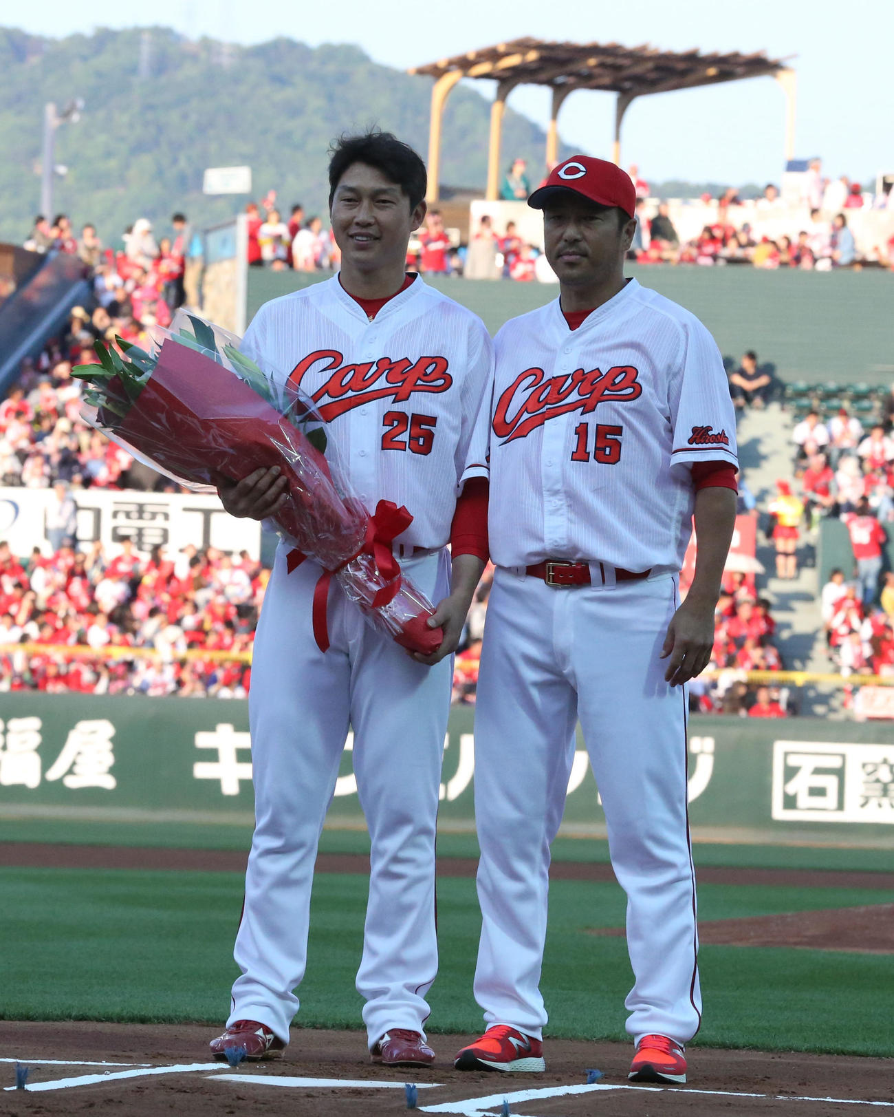 16年、2000安打達成記念セレモニーで黒田博樹（右）から花束を受け取った広島新井貴浩