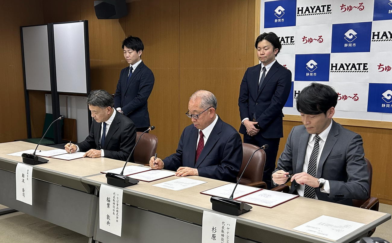 契約書に署名する出席者。左から難波市長、いなば食品の稲葉代表取締役、ハヤテ223の杉原代表