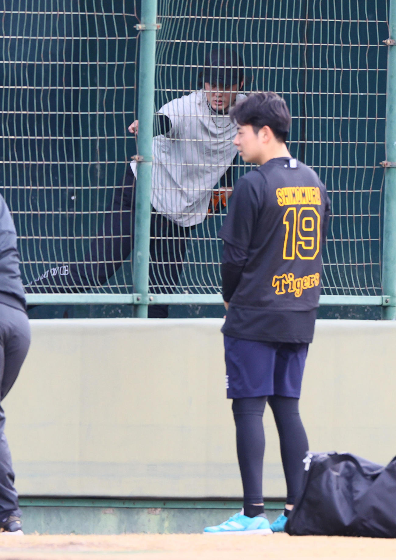 鳴尾浜球場のブルペンの藤浪（奥）を投球を見つめる阪神下村（撮影・上山淳一）