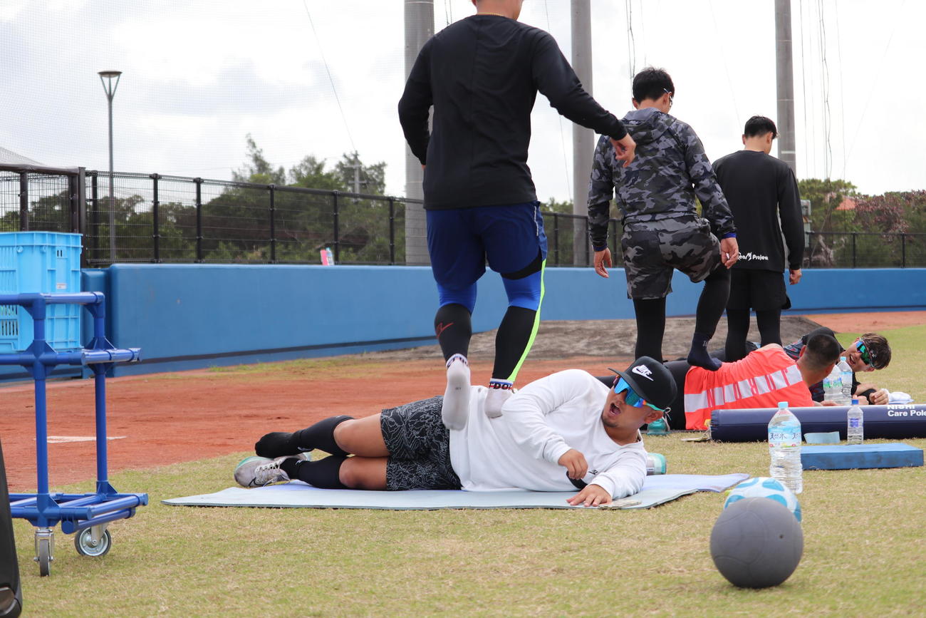 声を出しながら踏んでもらって腹筋を鍛えるオリックス森（撮影・大池和幸）