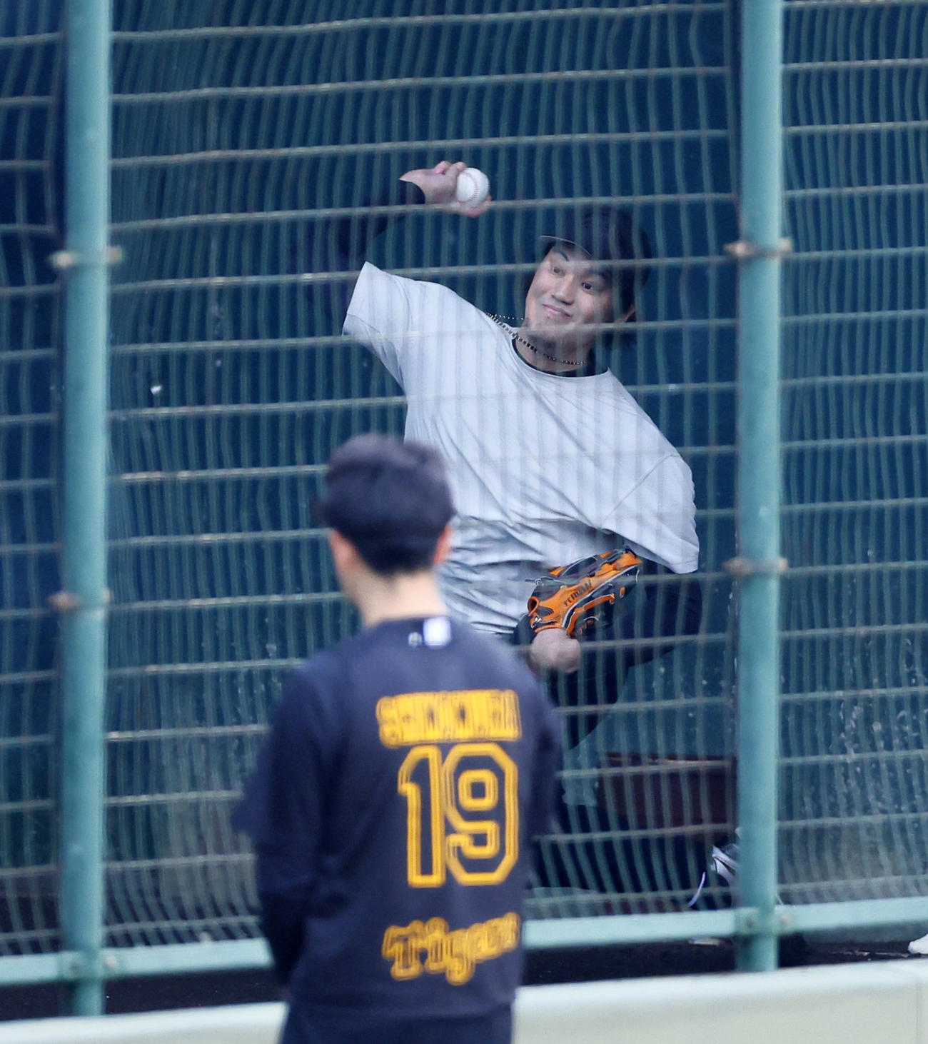 ブルペンで投球練習する藤浪を見つめる下村（撮影・藤尾明華）