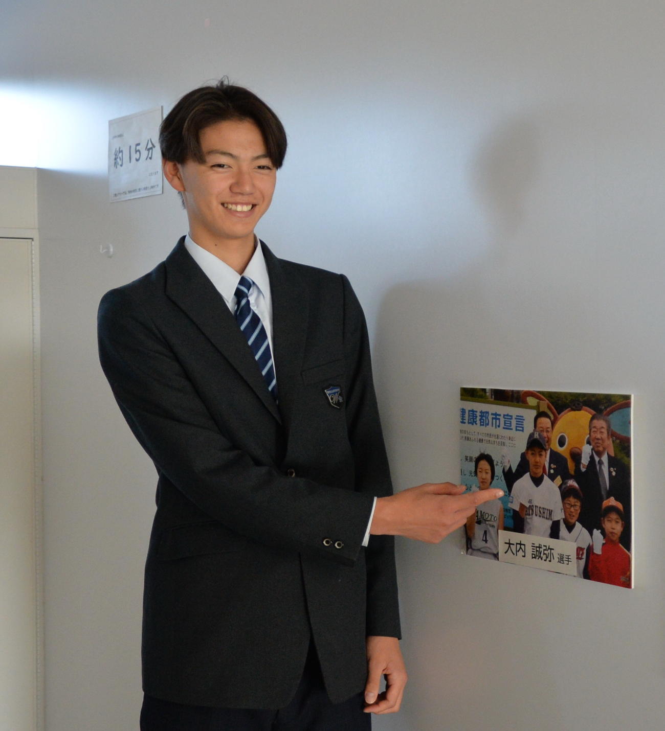 震災復興伝承館に飾られた自身の写真とともに写真を撮る楽天・大内（撮影・濱本神威）