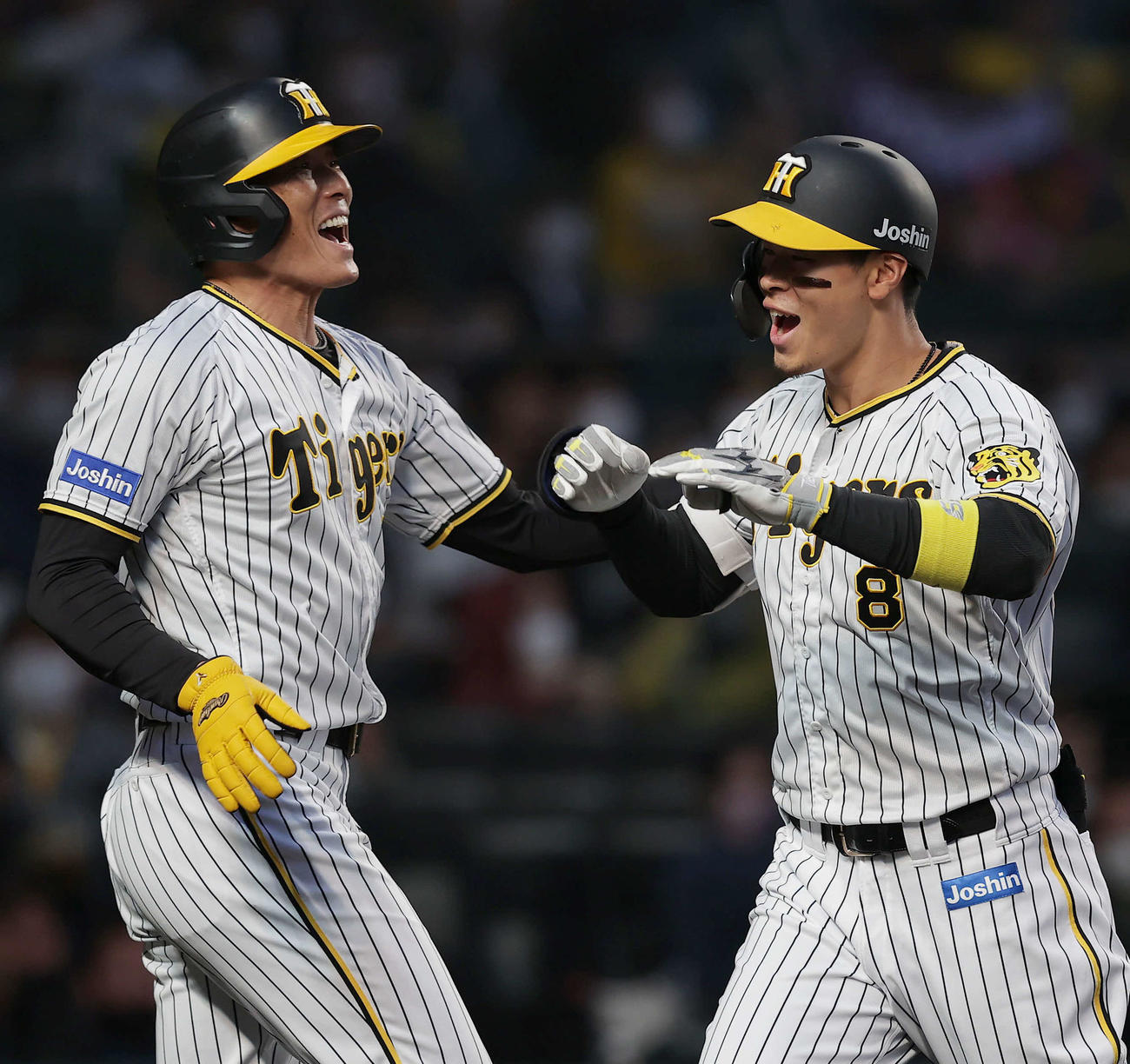 右越え本塁打の阪神佐藤輝（右）は糸井に迎えられる（2022年4月撮影）