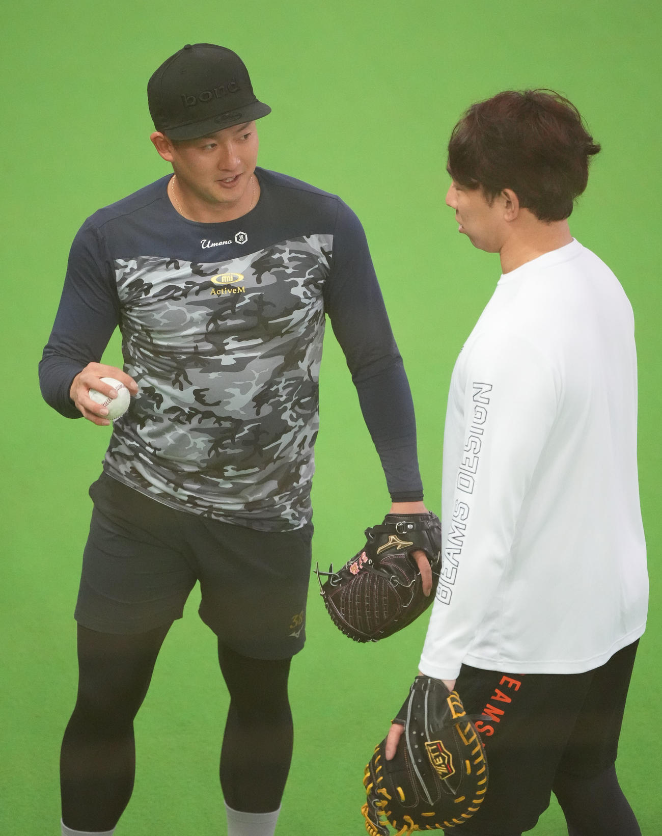 ブルペンで投球練習後、宇佐見と言葉を交わす梅野（左）（撮影・森本幸一）