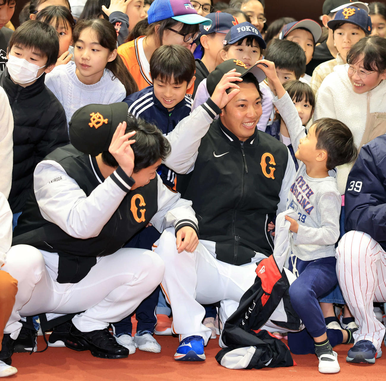 脱炭素アクションを学ぶ体験型イベントで、子どもに帽子を取られそうになる巨人赤星（右）。左は山崎伊（撮影・浅見桂子）