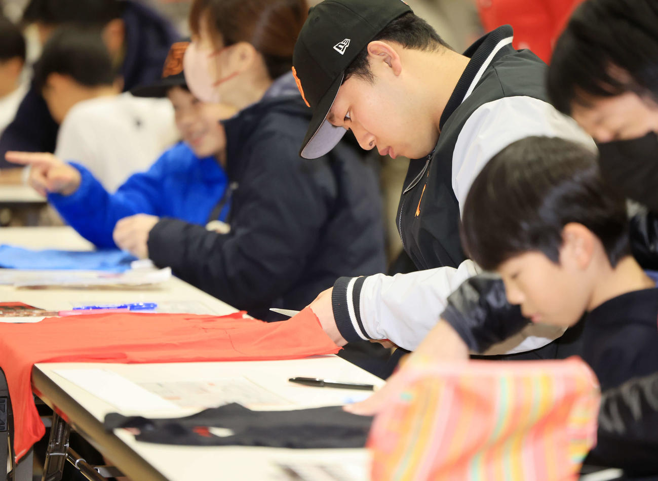 脱炭素アクションを学ぶ体験型イベントで、子どもたちと一緒に、真剣な表情でエコバックを作る巨人山崎伊（撮影・浅見桂子）