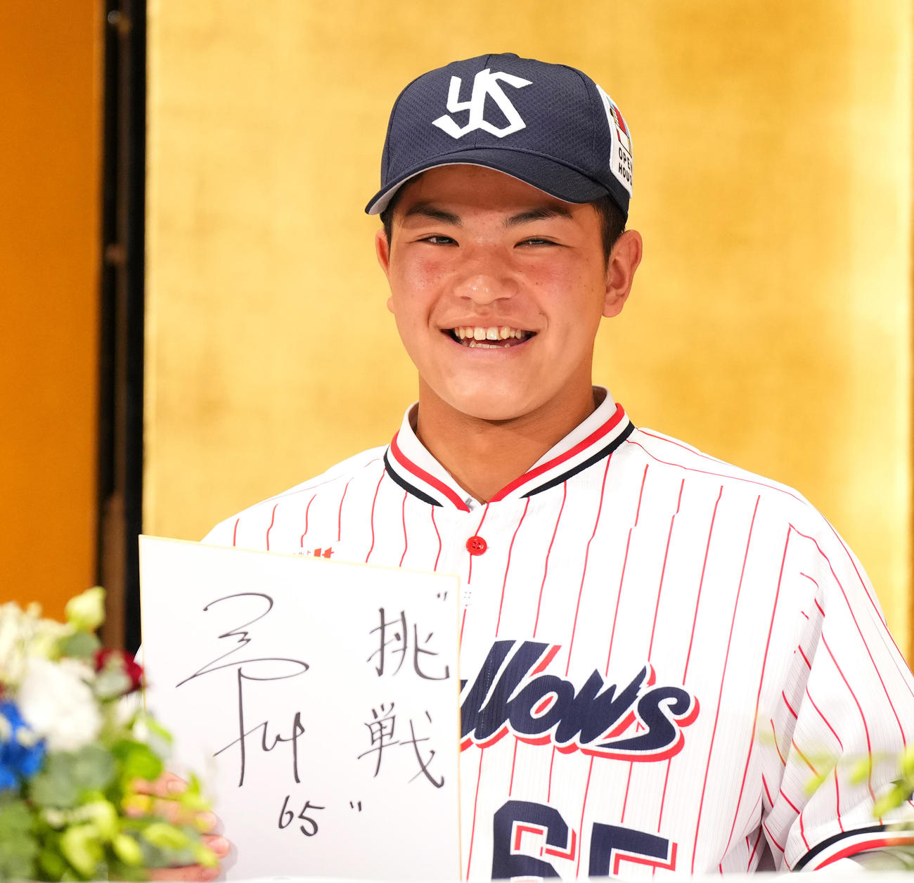 23年12月、ヤクルト新入団選手発表会で抱負を書いた色紙を手にするドラフト4位の鈴木