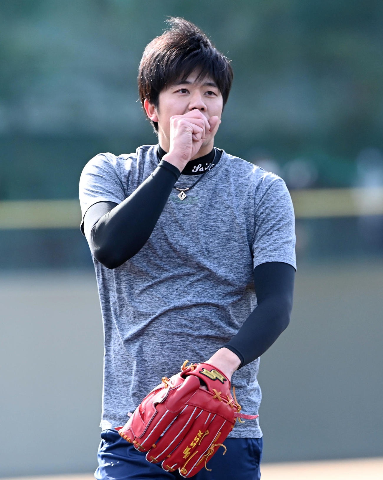 自主トレで手に息を吹きかける阪神才木（撮影・前岡正明）