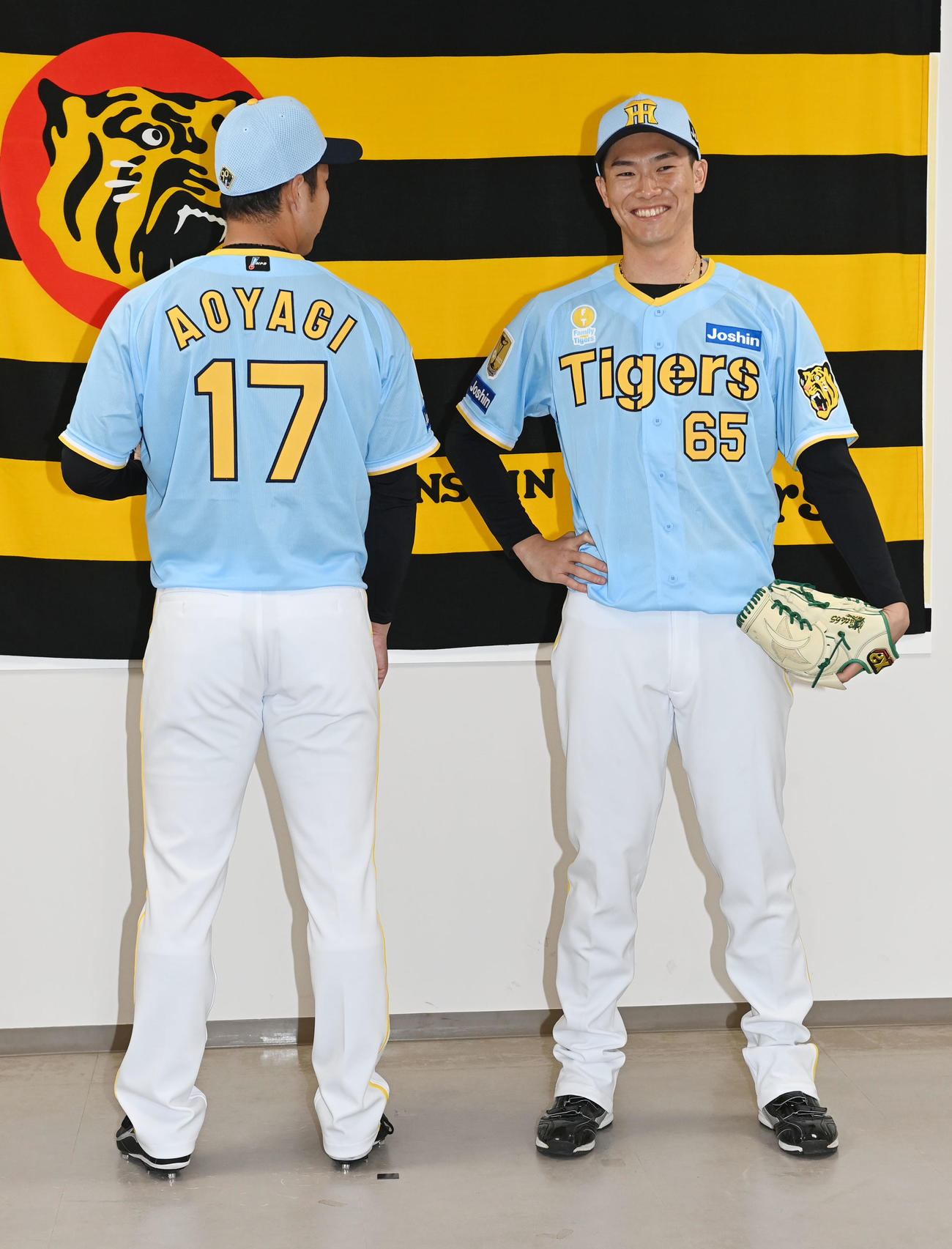 「Family with Tigers」の限定ユニホームを披露する阪神青柳（左）と湯浅（撮影・和賀正仁）