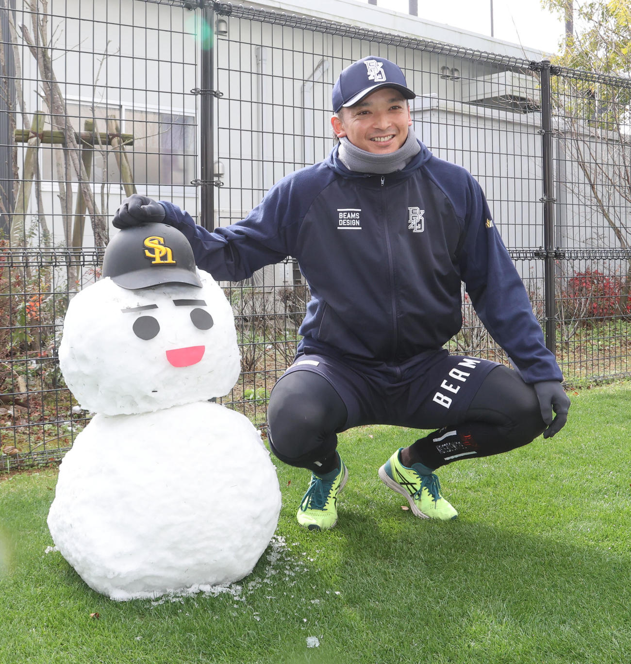 大寒波で雪の積もったタマホームスタジアム筑後、雪だるまの横で笑顔を見せる東浜（撮影・梅根麻紀）