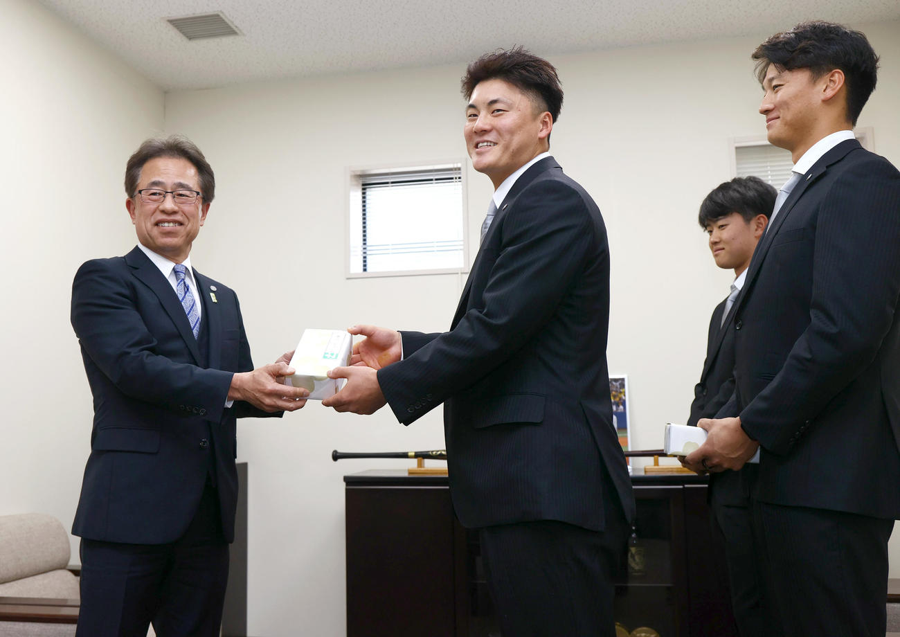 20歳記念贈呈式で阪神前川（中央）に記念品を贈る阪神粟井球団社長（撮影・上山淳一）