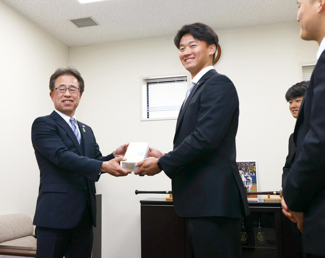 20歳記念贈呈式で阪神森木（左から2人目）に記念品を贈る阪神粟井球団社長（撮影・上山淳一）