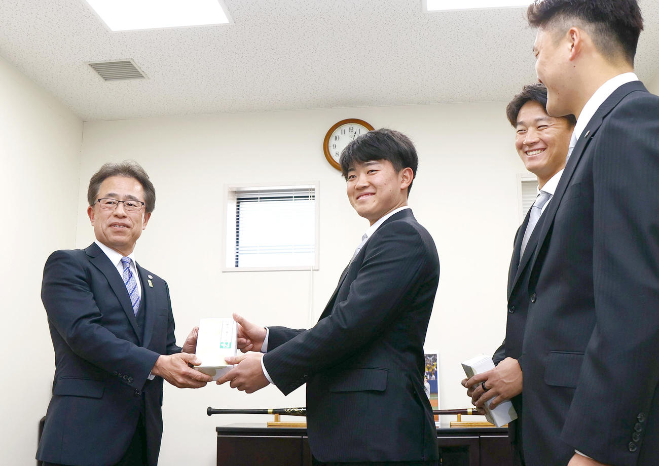 20歳記念贈呈式で阪神中川（左から2人目）に記念品を贈る阪神粟井球団社長（撮影・上山淳一）