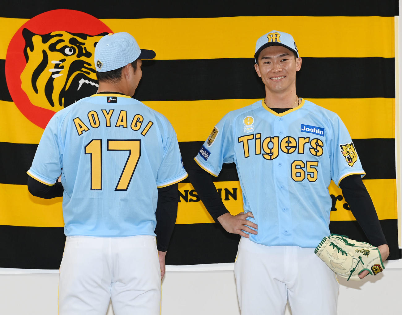 「Family with Tigers」の限定ユニホームを披露する阪神青柳（左）と湯浅（撮影・和賀正仁）