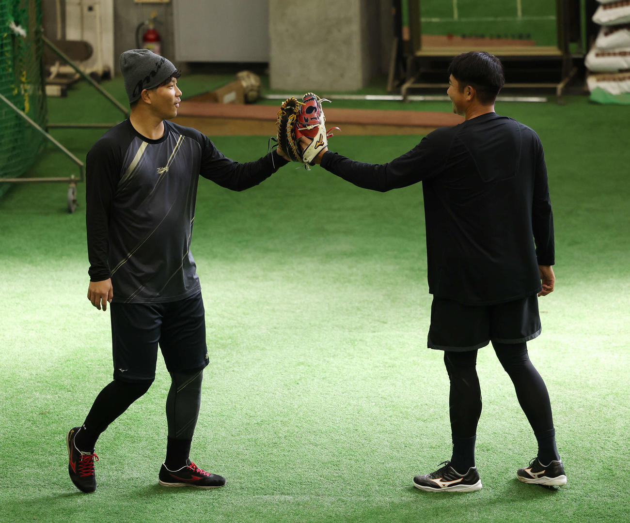 自主トレでブルペンを終え、タッチを交わす巨人大城卓（左）と菅野（撮影・宮地輝）