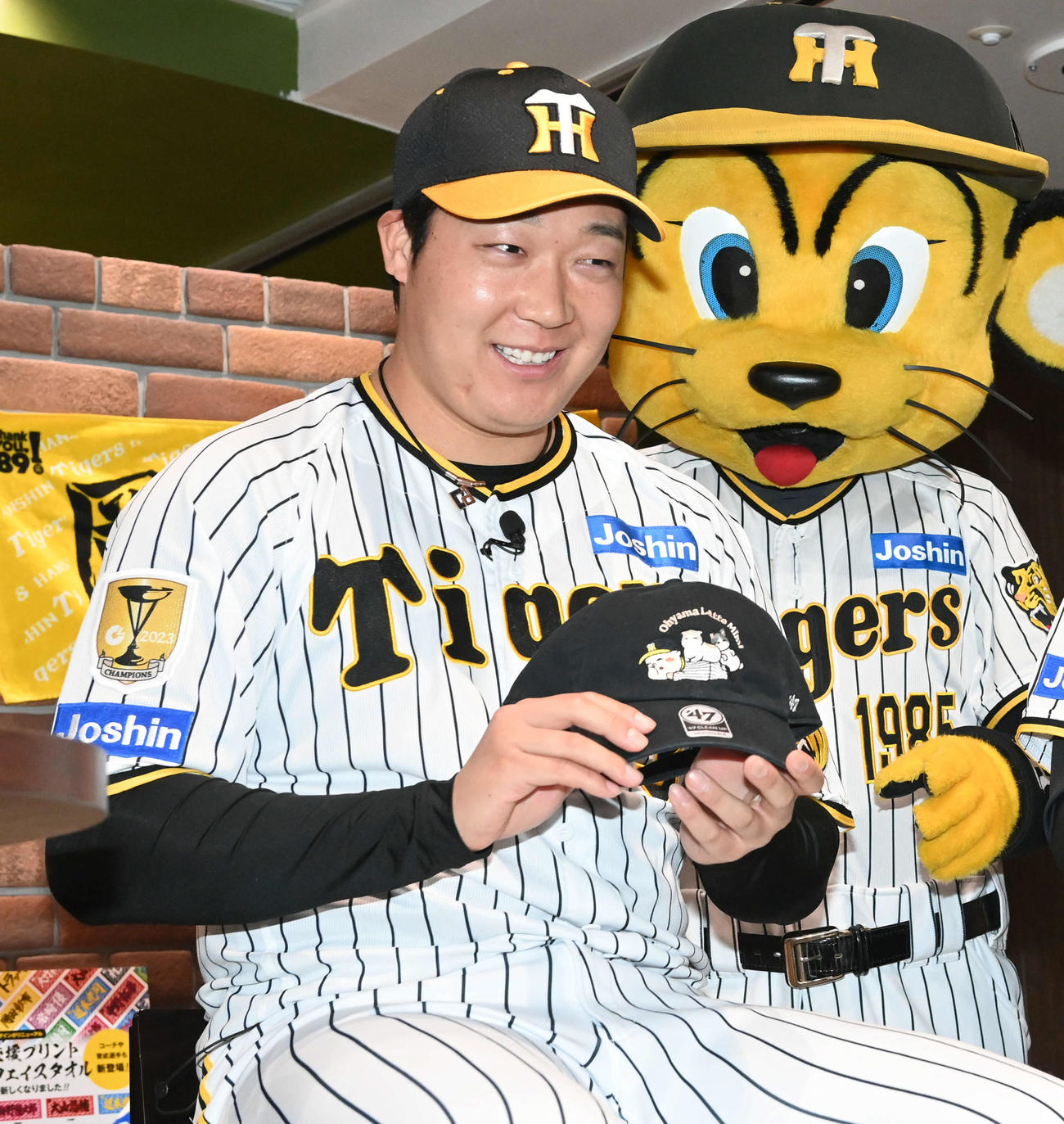 2024新作グッズで自身がデザインした猫の帽子を披露する大山（撮影・前岡正明）