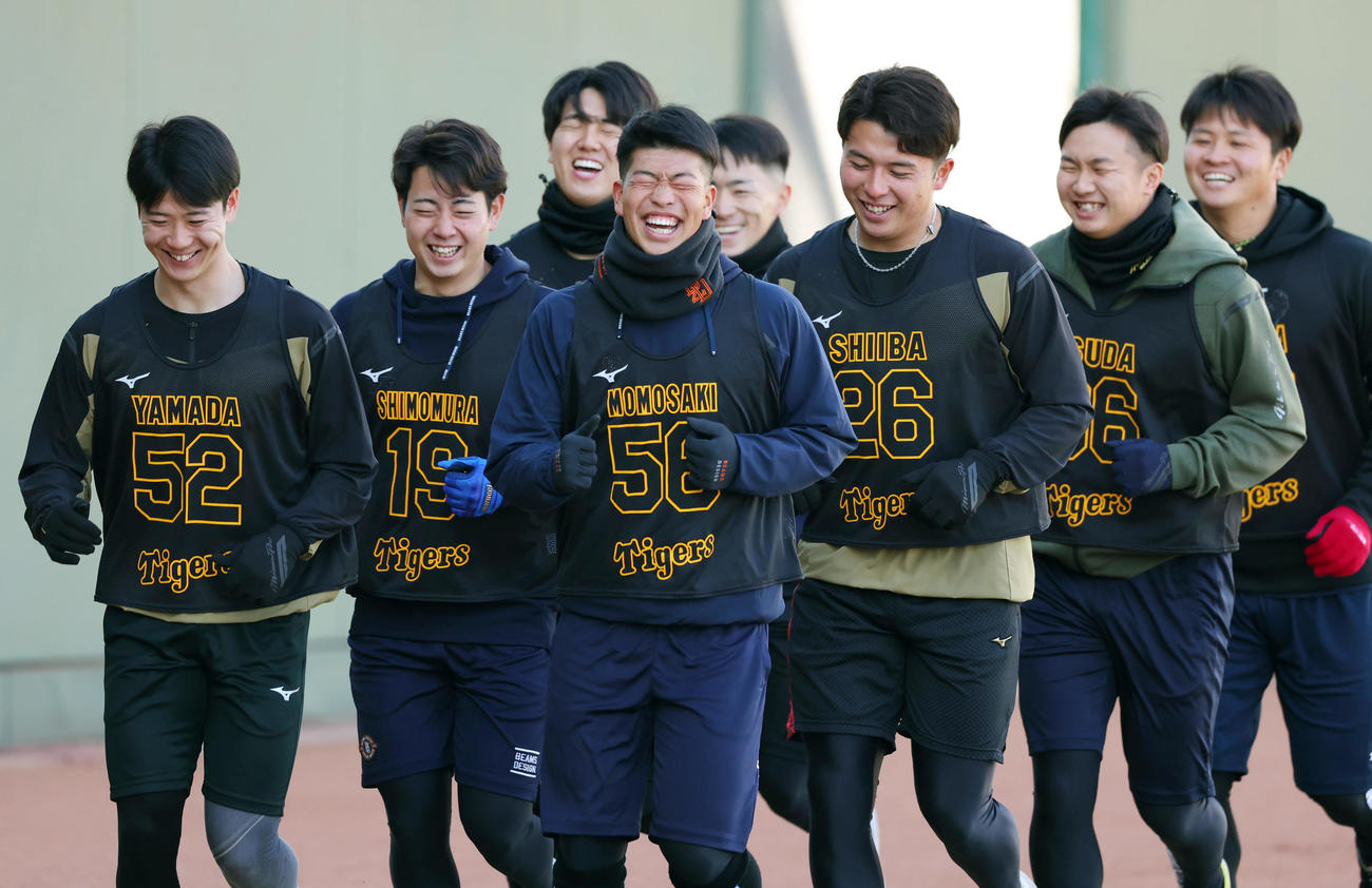 笑顔を見せながらランニングする阪神の新人選手たち。左から山田、下村、石黒、百崎、福島、椎葉、津田、松原（撮影・前田充）